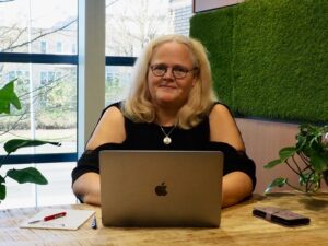 Vrouw met lang blond haar achter een PC
